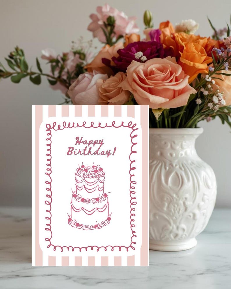 Puede incluir: Una tarjeta de cumplea&ntilde;os con un fondo a rayas rosas y blancas y un borde decorativo. La tarjeta presenta un dibujo de una tarta de varios pisos con cerezas y las palabras "Happy Birthday!". Un ramo de flores coloridas est&aacute; en un jarr&oacute;n blanco.