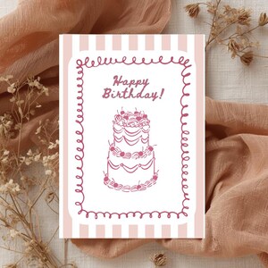 Puede incluir: Tarjeta de felicitaci&oacute;n de cumplea&ntilde;os con fondo a rayas rosas y blancas. La tarjeta presenta un borde rosa y las palabras "Happy Birthday!" encima de una ilustraci&oacute;n de pastel de dos pisos.