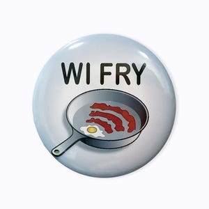 Puede incluir: Un botón azul y blanco con el texto "WI FRY" y una imagen de dibujos animados de una sartén con tocino y un huevo formando un símbolo de Wi-Fi.