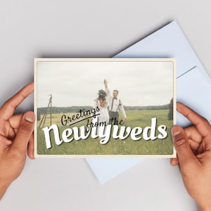 Customizable wedding thank you card template with retro postcard design and “Greetings from the Newlyweds” text. Editable Canva file with vintage aesthetic, used old paper style, and space for a wedding photo. Backside styled like a postcard for handwritten or digital notes. Perfect for newlyweds, printable wedding photo cards, modern vintage stationery, and travel-inspired wedding thank you cards. Canva template for wedding thank you photo card.