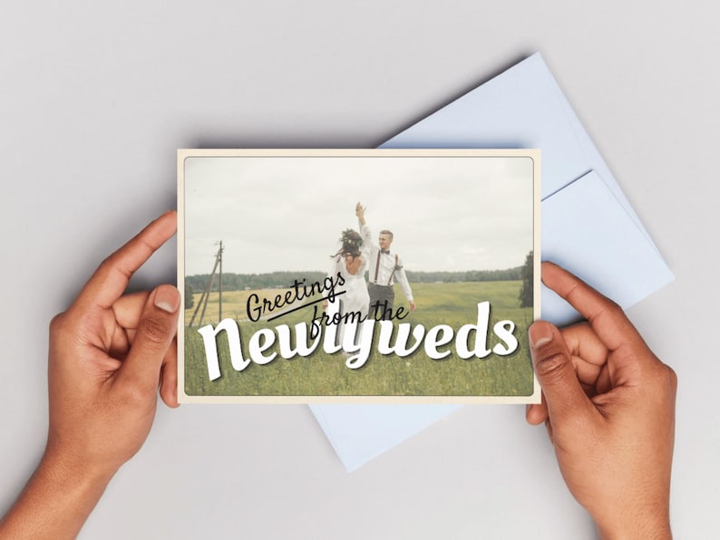 Customizable wedding thank you card template with retro postcard design and “Greetings from the Newlyweds” text. Editable Canva file with vintage aesthetic, used old paper style, and space for a wedding photo. Backside styled like a postcard for handwritten or digital notes. Perfect for newlyweds, printable wedding photo cards, modern vintage stationery, and travel-inspired wedding thank you cards. Canva template for wedding thank you photo card.
