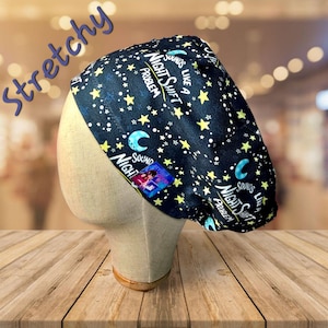May include: Black scrub hat with a white star and crescent moon pattern. The hat has the text "Sounds like a Night Shift Problem" printed on it.