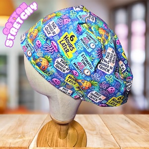 May include: A blue scrub cap featuring a colorful pattern of pineapples, jellyfish, and text that reads 6 HOURS LATER, THIS SHOULD BE QUICK, and ESTIMATED TIME 45 MINUTES. The fabric is printed with various cartoon-style icons and clock graphics.
