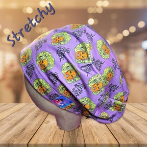May include: Purple stretchy fabric hat with a repeating pattern of a woman's face and the text "You Better Work".