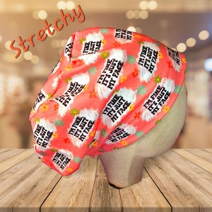 May include: A pink and white stretchy beanie with the text "I'm fine it's just my face" repeated in a pattern.