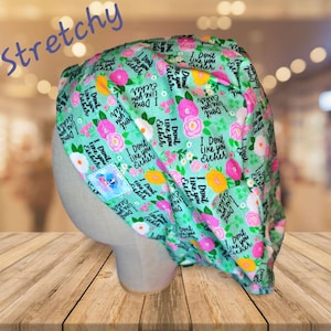 May include: A green and white scrub hat with a floral pattern and the text "I Don't Like You Either" repeated throughout.