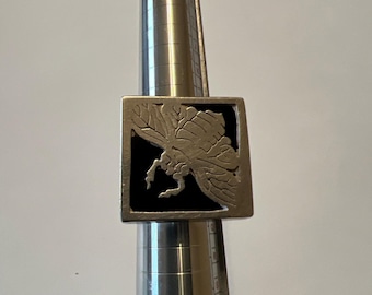 Puede incluir: Un anillo de plata con una incrustación de esmalte negro que presenta un diseño de corte detallado de una polilla.