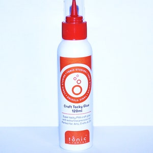 May include: A clear plastic bottle with a red cap and a red nozzle. The bottle contains a white liquid and is labeled "Craft Tacky Glue 120ml". The label also says "Super tacky PVA craft glue with extra fine precision tip. Perfect for: Arts, Crafts & DIY". The bottle is labeled with the brand name "tonic studios".