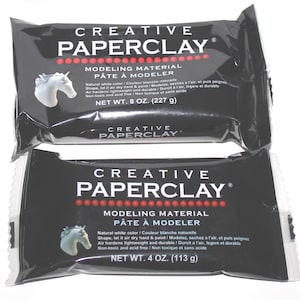 May include: Two black packages of Creative Paperclay modeling material. The packages have white text and a white unicorn graphic. One package contains 8 oz (227 g) and the other contains 4 oz (113 g) of the air-hardening, lightweight, and durable clay.