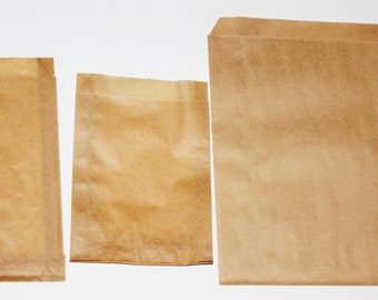 May include: Three brown paper bags of different sizes. The bags are made of a thin, crinkled paper and have a natural brown color.