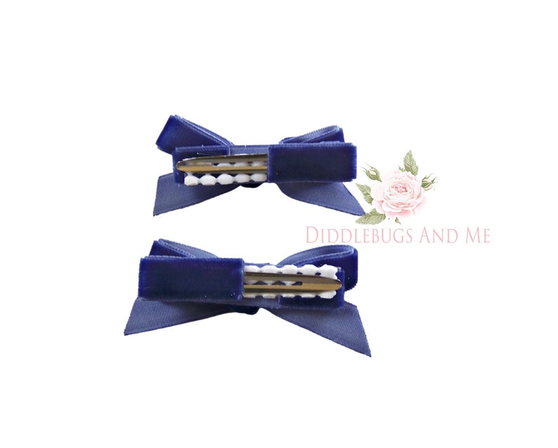 May include: Two navy blue velvet hair bows with white polka dot clips.