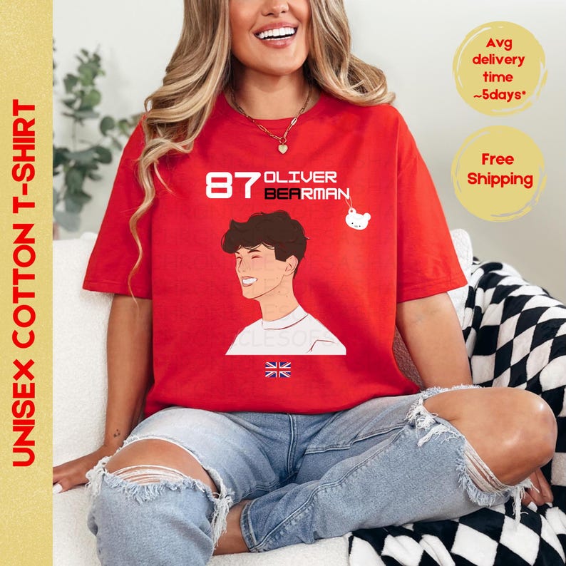 May include: Red cotton t-shirt featuring a cartoon illustration of a young man with the text "87 OLIVER BEARMAN" and a small cartoon bear. The shirt also features a Union Jack flag.