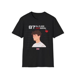 May include: Black t-shirt featuring a white illustration of a person with the text "87 Oliver Bearman" in red.