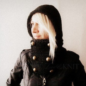 May include: A black hooded cowl with a ribbed texture and decorative buttons. The cowl is made of a soft, warm material and is perfect for keeping warm in the winter.