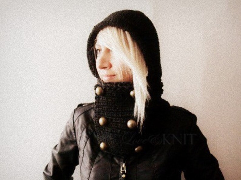 May include: A black hooded cowl with a ribbed texture and decorative buttons. The cowl is made of a soft, warm material and is perfect for keeping warm in the winter.