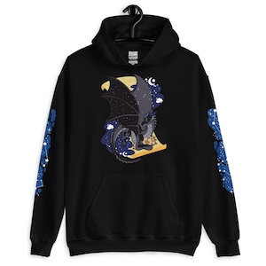 Könnte beinhalten: Schwarzer Kapuzenpullover mit einer Drachenillustration und Sternenflügeldesign. Der Drache ist grau mit grünen Augen, vor dem Hintergrund eines Mondes und Nachthimmels. Die Ärmel haben ein blaues Sternbildmuster.