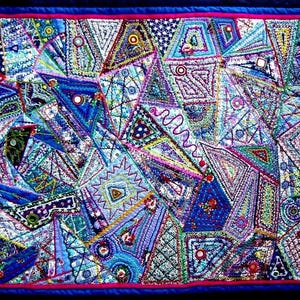 Peut inclure: Une courtepointe colorée en patchwork avec un motif géométrique. La courtepointe est faite de différents tissus dans des tons de bleu, rose, violet et vert. La courtepointe est cousue avec des broderies complexes.