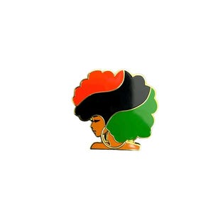 May include: A gold-toned pin featuring a profile of a woman with a colorful afro. The hair is divided into sections of red, black, and green. The woman has a gold hoop earring and a gold outline.