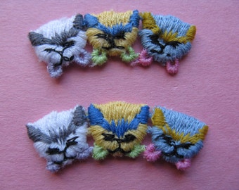 May include: Six embroidered iron-on patches featuring cartoon animal faces. The patches are in shades of gray, yellow, blue, and pink.