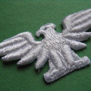 May include: White embroidered iron-on patch of an eagle with wings spread.
