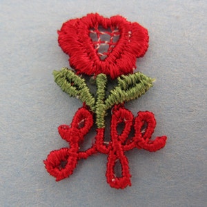 May include: Red embroidered flower with green leaves and the word "Life" in red embroidery.