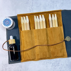 May include: A brown leather roll-up case with a brown leather strap and a metal clasp. The case contains 10 bamboo calligraphy nibs.