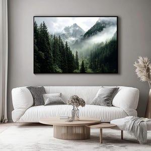 May include: A photograph of a mountain range with a thick fog rolling through the trees. The trees are a dark green and the mountains are a light gray. The fog is a white and gray color.