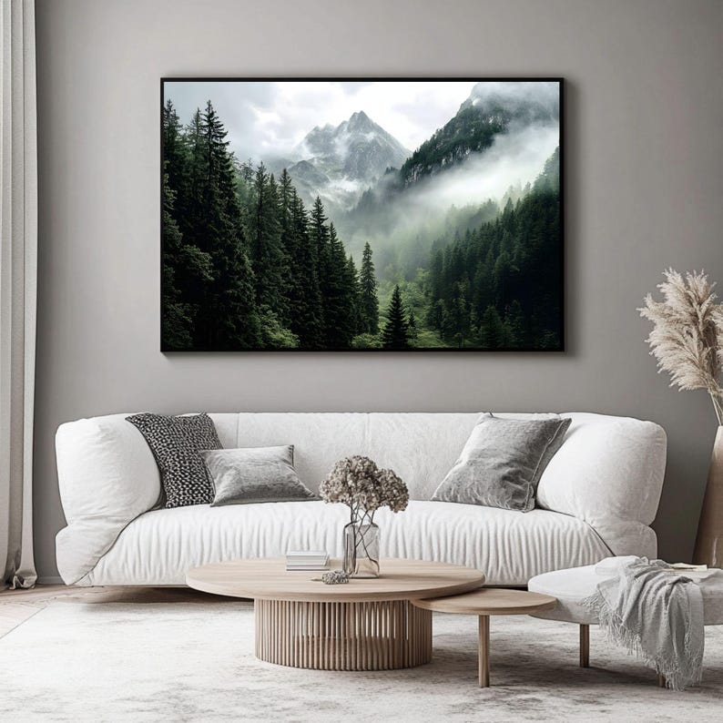 May include: A photograph of a mountain range with a thick fog rolling through the trees. The trees are a dark green and the mountains are a light gray. The fog is a white and gray color.