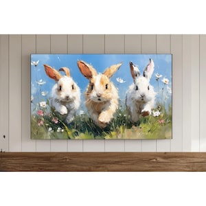 May include: A framed painting showing three rabbits running through a field of wildflowers. The rabbits have white and tan fur and long ears. The background is a blue sky with white flowers and green grass.