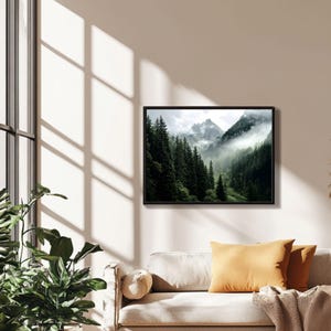 May include: A photograph of a mountain range with a thick layer of fog covering the peaks. The mountains are covered in lush green trees.