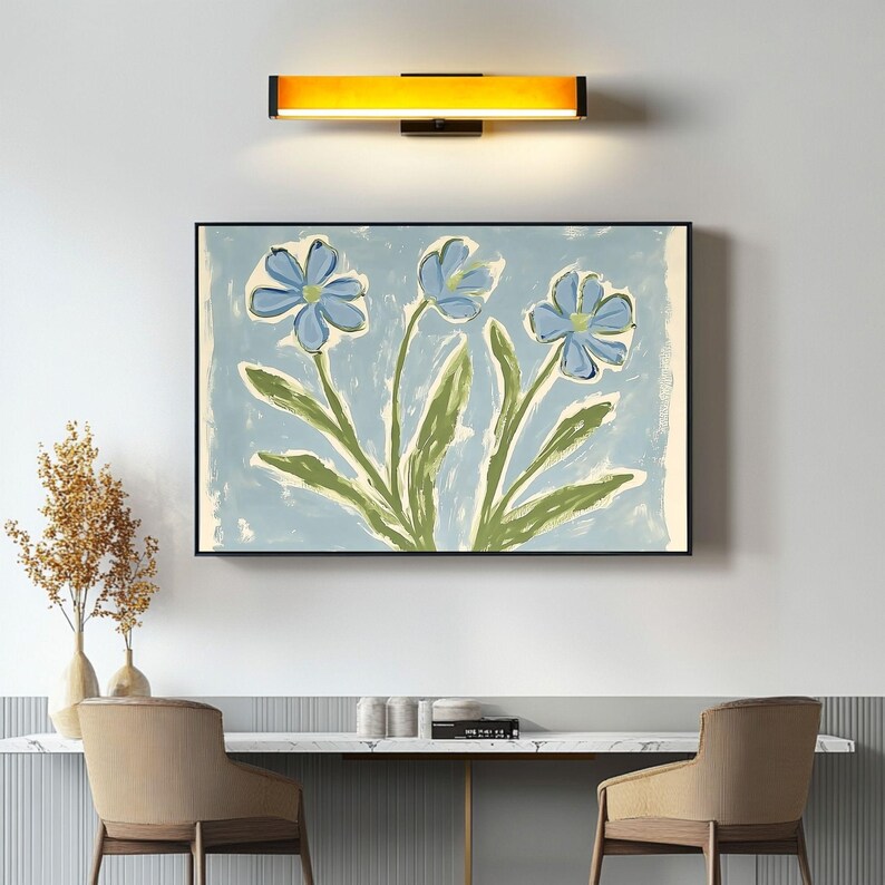 Puede incluir: Una pintura enmarcada de tres flores azules con tallos y hojas verdes sobre un fondo azul claro.