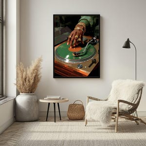 May include: A framed art print featuring a DJ's hand adorned with gold jewelry, manipulating a green vinyl record on a turntable. The artwork has a retro aesthetic, with a brown and green color palette.