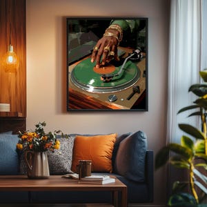 May include: A framed art print depicts a DJ's hand on a green vinyl record. The DJ's hand is adorned with gold rings and bracelets. The turntable is set against a neutral background, creating a modern, artistic vibe.