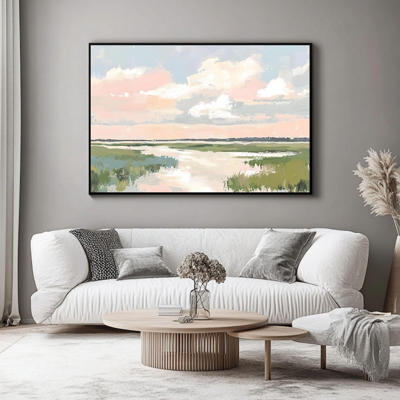 May include: A painting of a landscape with a river flowing through a field of green grass. The sky is a soft pink and blue with fluffy white clouds.