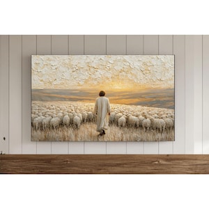 May include: An oil painting showing a figure in a white robe walking towards a flock of sheep. The artwork features a textured sky with warm, golden hues, and the sheep are arranged in rows. The painting is framed in black and mounted on a white wall.