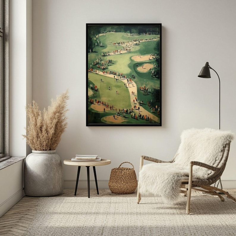 Może przedstawiać: Oprawiony wydruk przedstawiający scenę z pola golfowego z graczami i widzami. Grafika przedstawia zielony fairway, pułapki piaskowe i krętą ścieżkę. Wydruk jest eksponowany w pokoju o neutralnej palecie kolor&oacute;w, z dekoracyjnym wazonem i wiklinowym krzesłem.