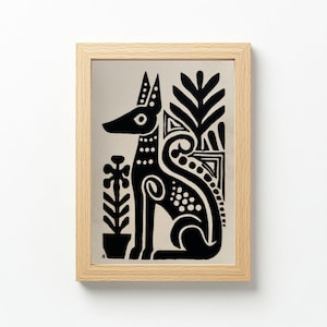 May include: A framed black and white art print featuring a stylized dog with decorative floral elements. The dog is sitting, with a long snout and pointed ears. The artwork is in a light wood frame.