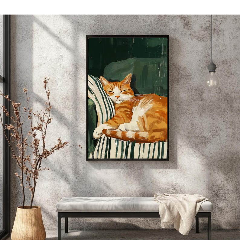 Pu&ograve; includere: Stampa artistica incorniciata di un gatto tabby arancione che dorme. Il gatto &egrave; rannicchiato su una sedia a strisce verdi e bianche. L'opera d'arte &egrave; esposta in una stanza con una palette di colori neutri, una panca e un vaso decorativo.