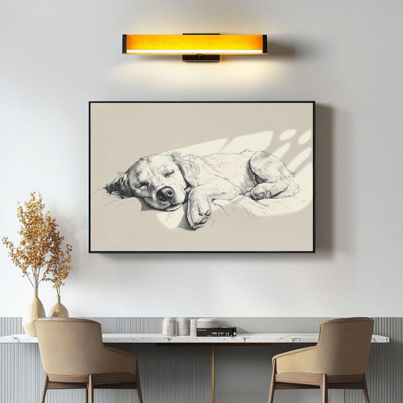 May include: A framed monochrome print depicting a sleeping dog. The artwork shows a detailed pencil sketch of a dog lying down. The print is displayed above a desk with two chairs, creating a calming aesthetic.