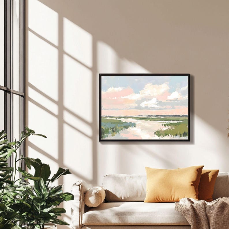 May include: A framed painting of a landscape with a river flowing through a field of green grass. The sky is a light blue with pink clouds.