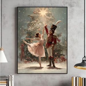 May include: A framed print depicts a ballet dancer and a toy soldier in front of a Christmas tree. The dancer wears a pink tutu, and the soldier is in a red uniform. The background is a snowy scene with a star on top of the tree.