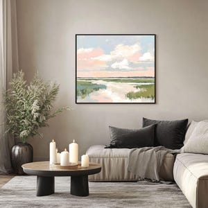 May include: A framed abstract painting of a landscape with a river, green grass, and a pink and blue sky with white clouds.