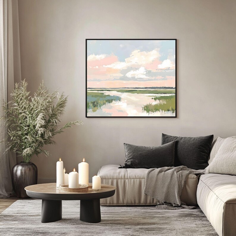 May include: A framed abstract painting of a landscape with a river, green grass, and a pink and blue sky with white clouds.