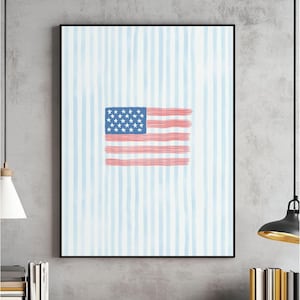 May include: Framed artwork featuring a stylized American flag design. The flag is rendered in red, white, and blue, with a blue field of stars and red and white stripes. The background has vertical blue and white stripes.