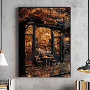 May include: A framed print depicting a charming bookstore. The shop, with the text "ROSE BOOK" above the entrance, is lit by warm lights, with books visible inside. Two wooden chairs and a small table are outside, beneath a tree with autumnal leaves.