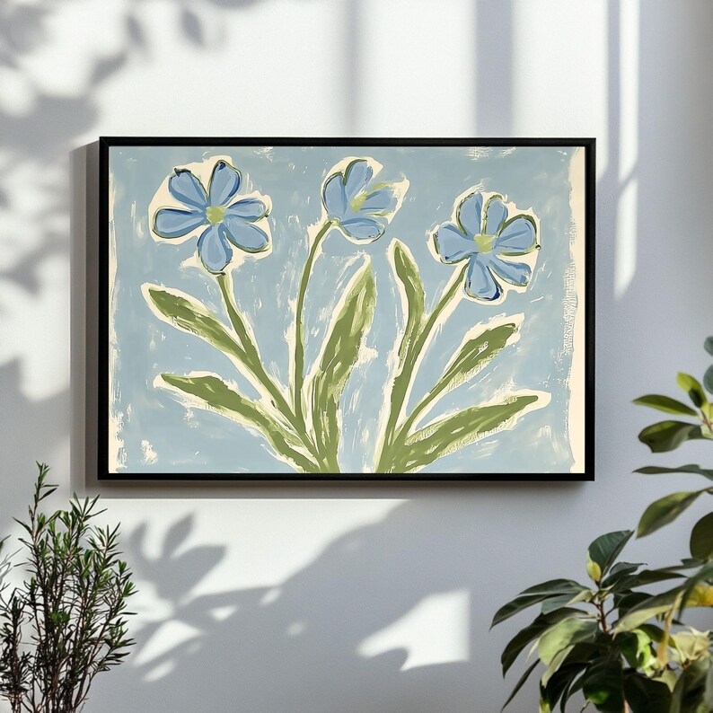 Puede incluir: Una pintura enmarcada de tres flores azules con tallos y hojas verdes sobre un fondo azul claro.