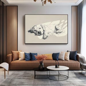 May include: A monochrome sketch of a sleeping dog in a black frame. The artwork hangs above a brown sofa with cushions. A coffee table and rug are in front of the sofa. The room has neutral tones and natural light.