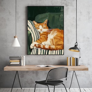 Pu&ograve; includere: Una stampa artistica incorniciata raffigura un gatto arancione addormentato su un cuscino a righe. Il gatto &egrave; raggomitolato, con gli occhi chiusi. Lo sfondo &egrave; verde scuro e la cornice &egrave; nera.