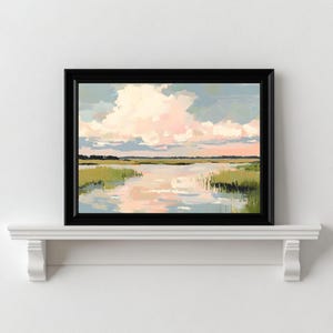 May include: A framed painting depicting a landscape with a river and green reeds in the foreground. The sky is a soft blue with pink and white clouds.