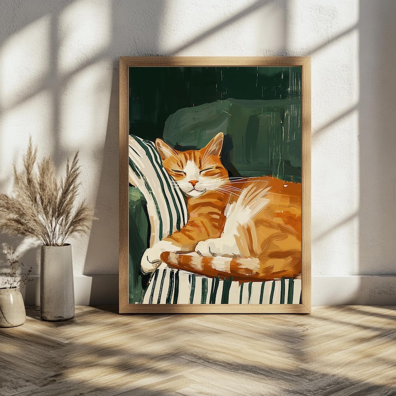 Pu&ograve; includere: Una stampa artistica incorniciata raffigura un gatto rosso addormentato su una sedia a strisce verdi e bianche. Il gatto &egrave; rannicchiato, con gli occhi chiusi, in una postura rilassata. L'opera d'arte ha un'atmosfera calda e invitante, adatta all'arredamento.